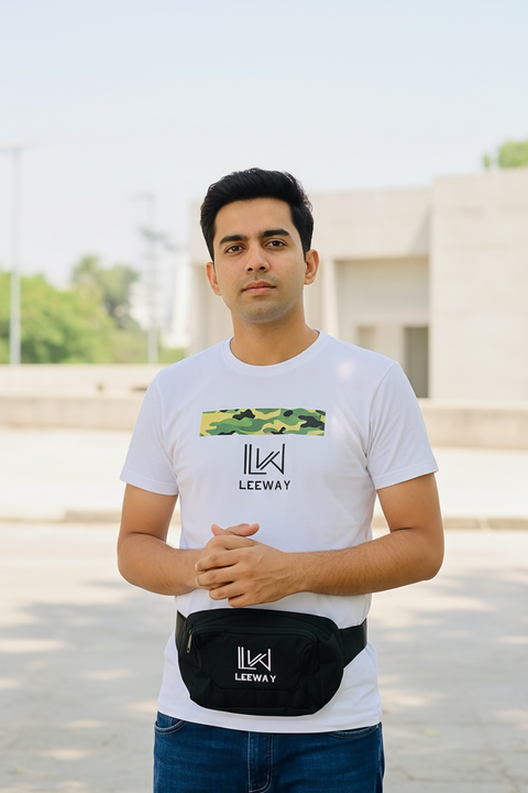 Man wearing a white t-shirt with a logo and carrying a black bag with a logo, standing outdoors.